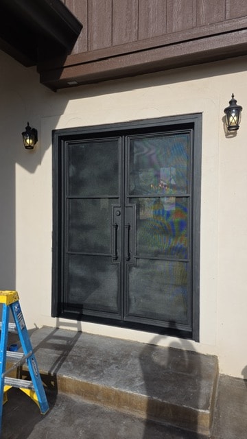 Iron double door with wall sconces
