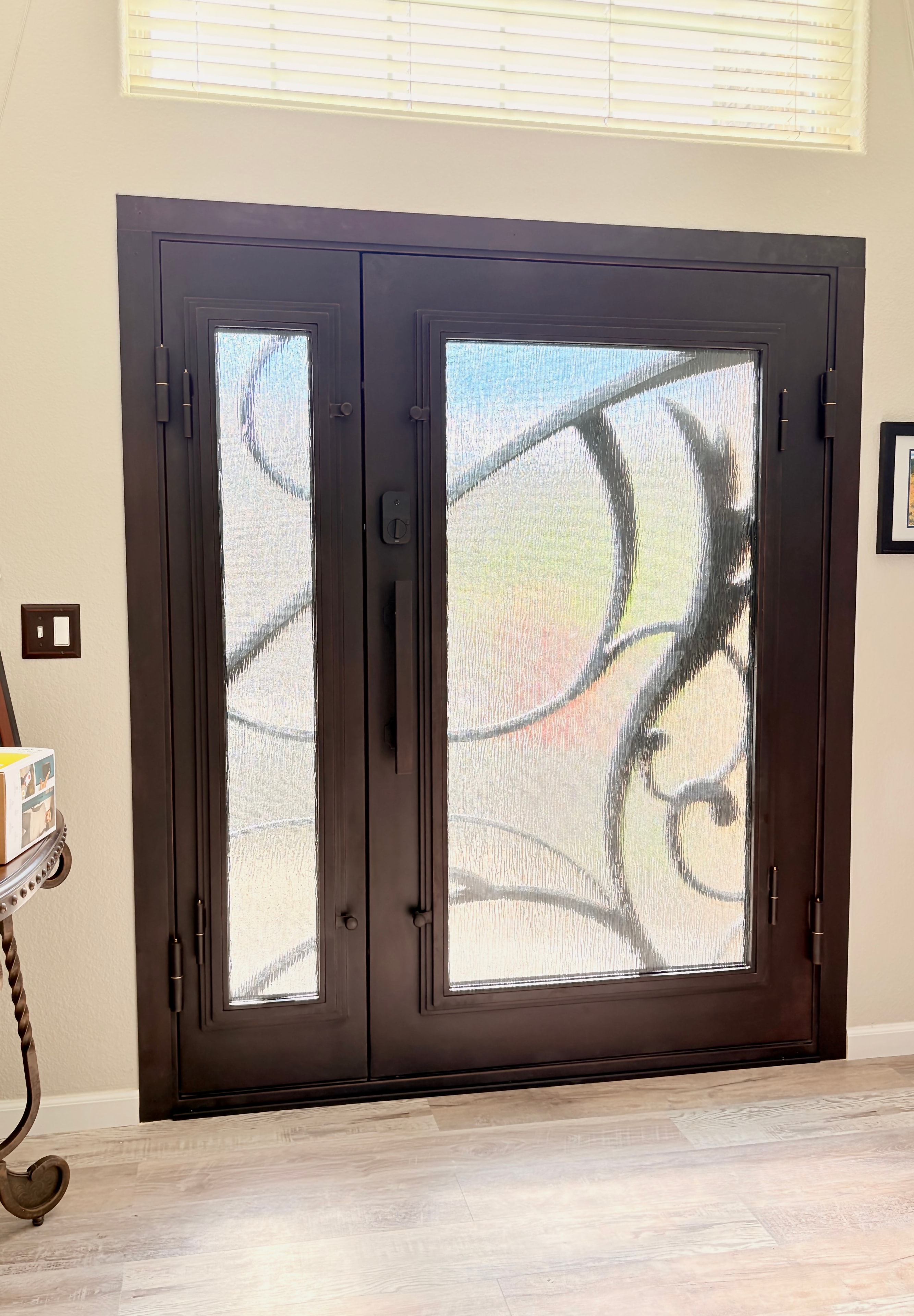 After — custom iron door with scrollwork and textured glass, interior view