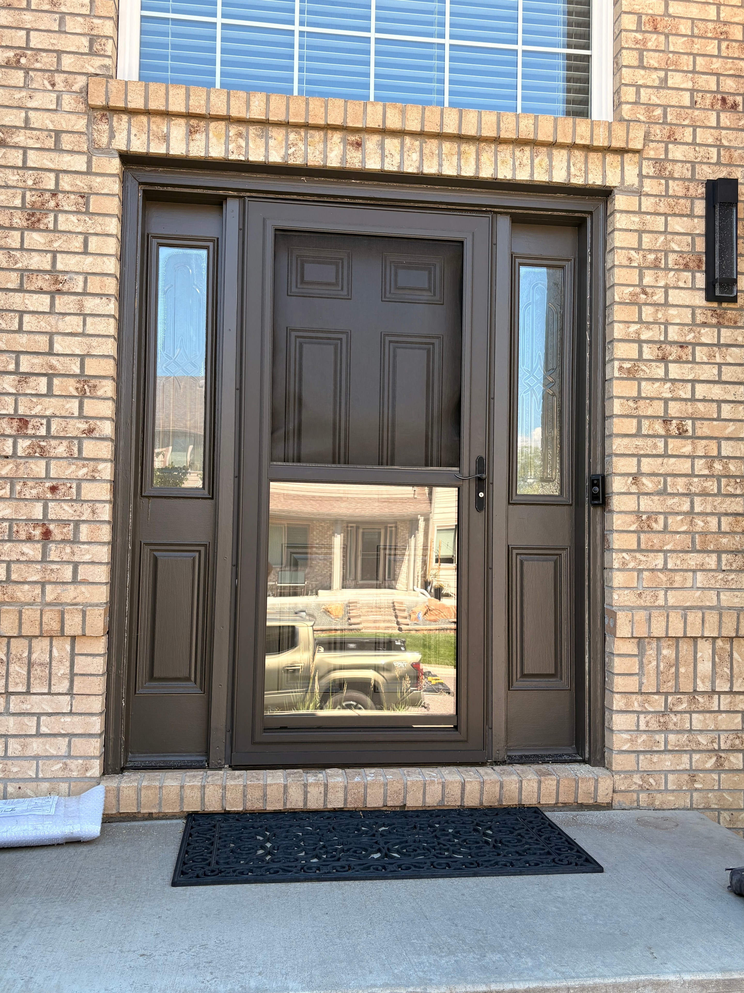Before — original brown storm door with sidelights on brick home