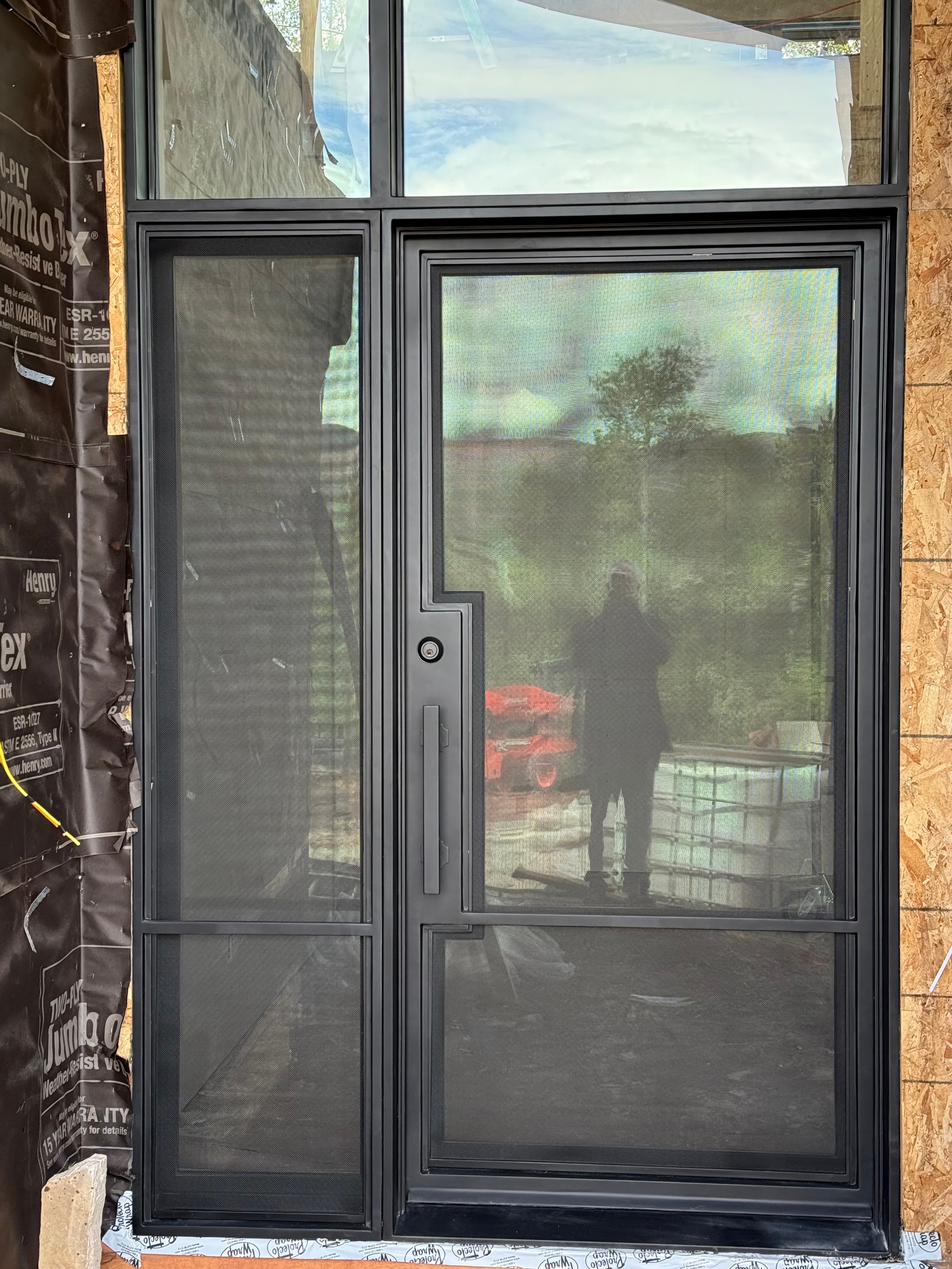Iron door with mesh glass and sidelights, exterior view