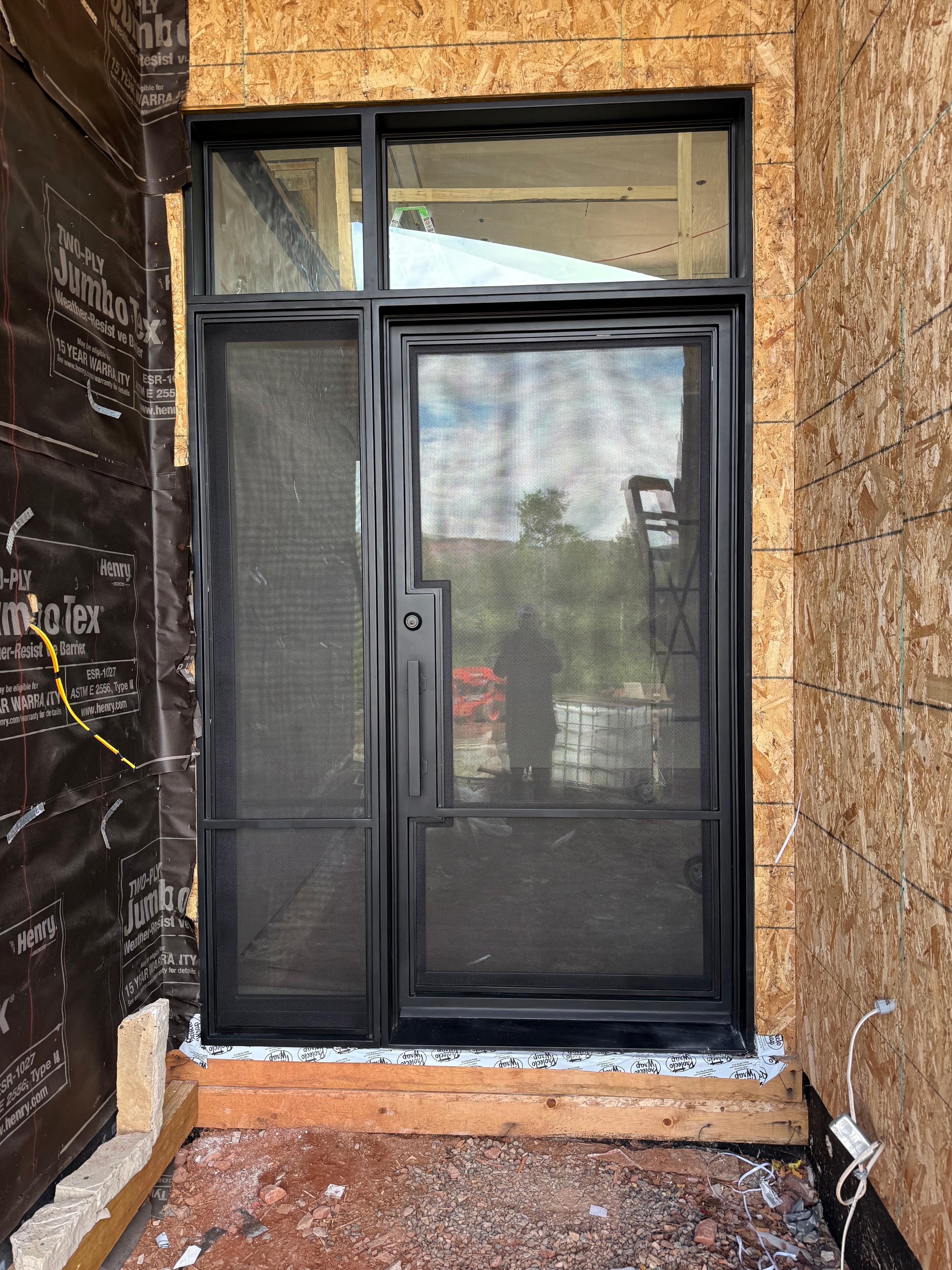 Iron door with sidelights and mesh glass, exterior framing view